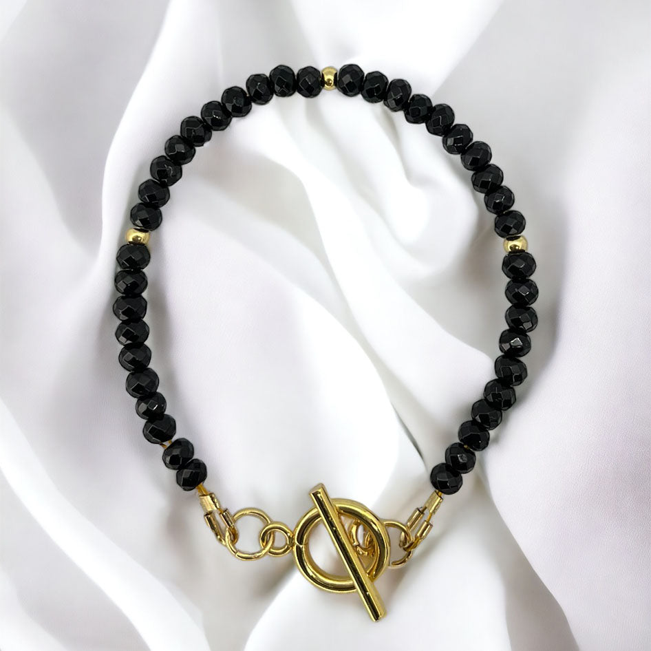 Elegantný dámsky náramok Black Onyx s pozlátenými detailmi, symbol odolnosti a ochrany.